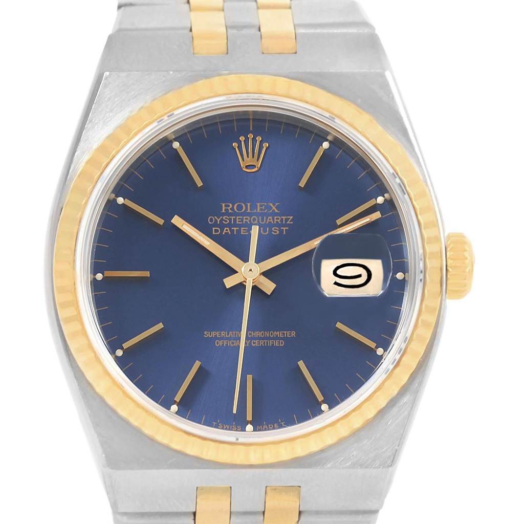The image shows a close-up, front view of a Rolex Oysterquartz 17013 Men's Stainless Steel Blue Dial 17013 Men's Stainless Steel Blue Dial watch, highlighting its blue dial, gold bezel, and date window.
