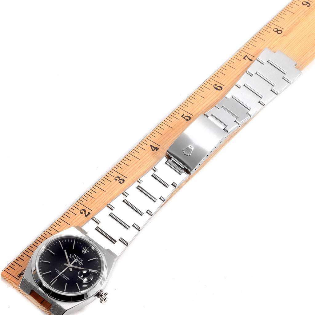 The image shows a Rolex Oysterquartz 17000 Men's Stainless Steel Black Dial 17000 Men's Stainless Steel Black Dial watch laid flat with a ruler measuring the metal bracelet.
