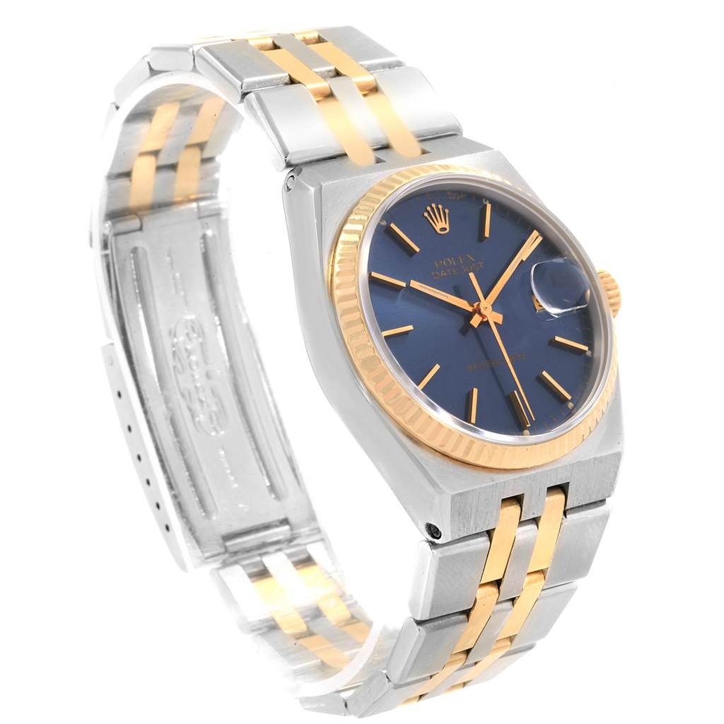 The Rolex Oysterquartz 17013 Men's Stainless Steel Blue Dial 17013 Men's Stainless Steel Blue Dial watch is shown at an angled view, highlighting its gold and silver bracelet, blue dial, and fluted bezel.