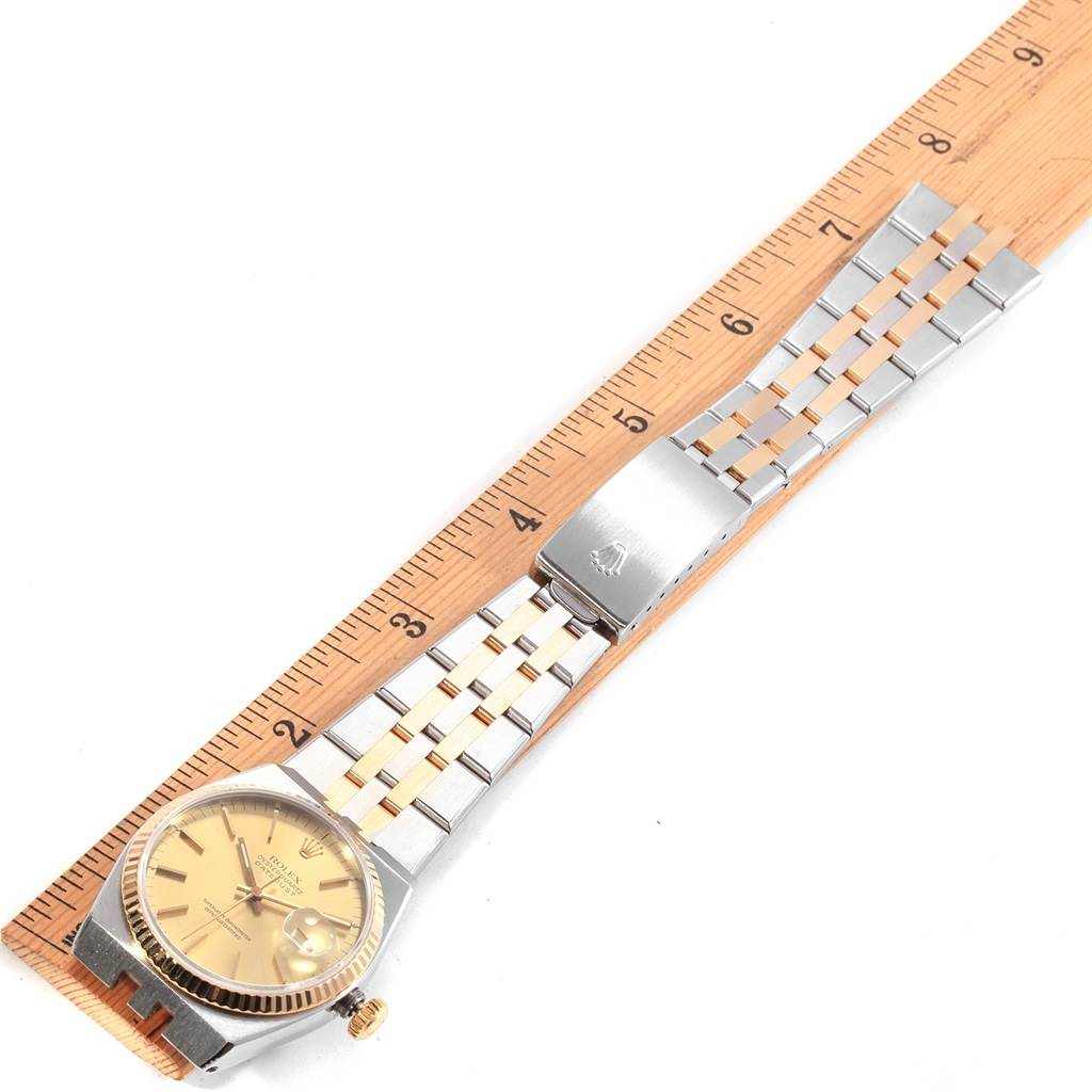 The image shows a Rolex Oysterquartz 17013 Men's Stainless Steel Champagne Dial 17013 Men's Stainless Steel Champagne Dial watch from an overhead angle, highlighting the dial, bracelet, and clasp against a ruler for scale.