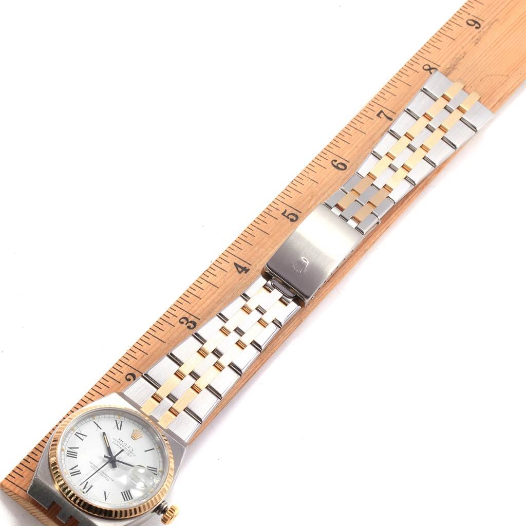 The image shows a top-down view of a Rolex Oysterquartz 17013 Men's Steel and Gold (two tone) White Dial 17013 Men's Steel and Gold (two tone) White Dial watch with the face, bracelet, and clasp visible, alongside a measuring ruler.