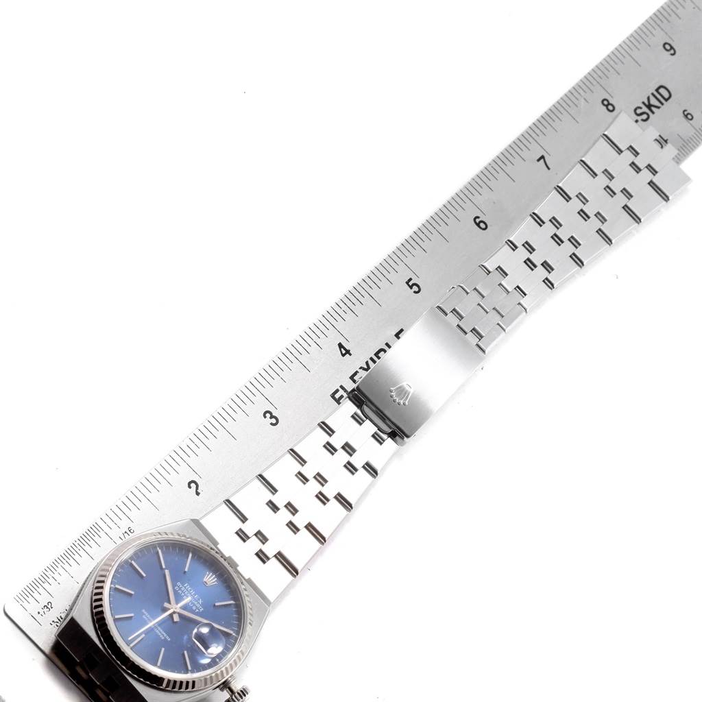 The image shows a Rolex Oysterquartz 17014 Men's Stainless Steel Blue Dial 17014 Men's Stainless Steel Blue Dial watch and part of its metal bracelet band lying beside a measuring ruler.