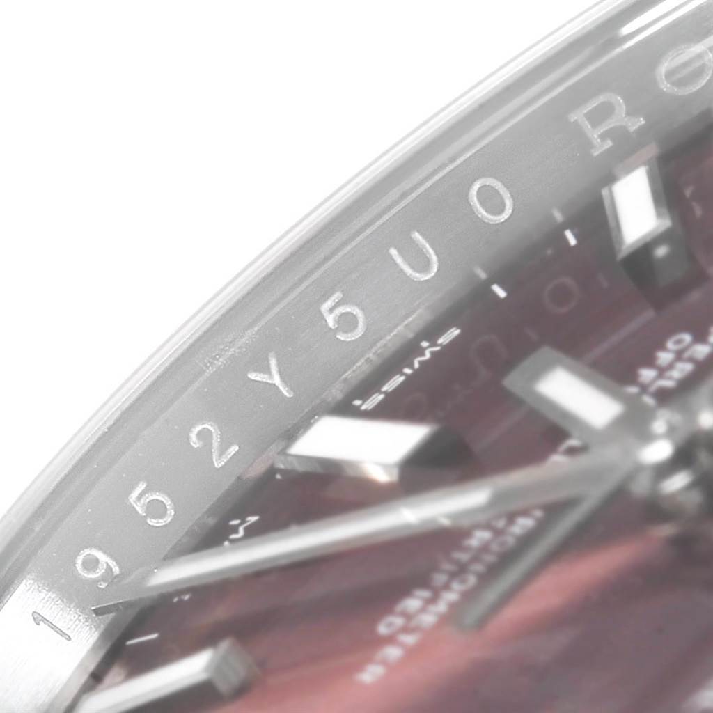 The image shows a close-up of the dial, hands, and inner bezel of a Rolex Oysterquartz 114200 Men
s Stainless Steel Burgundy Dial 114200 Men
s Stainless Steel Burgundy Dial watch.