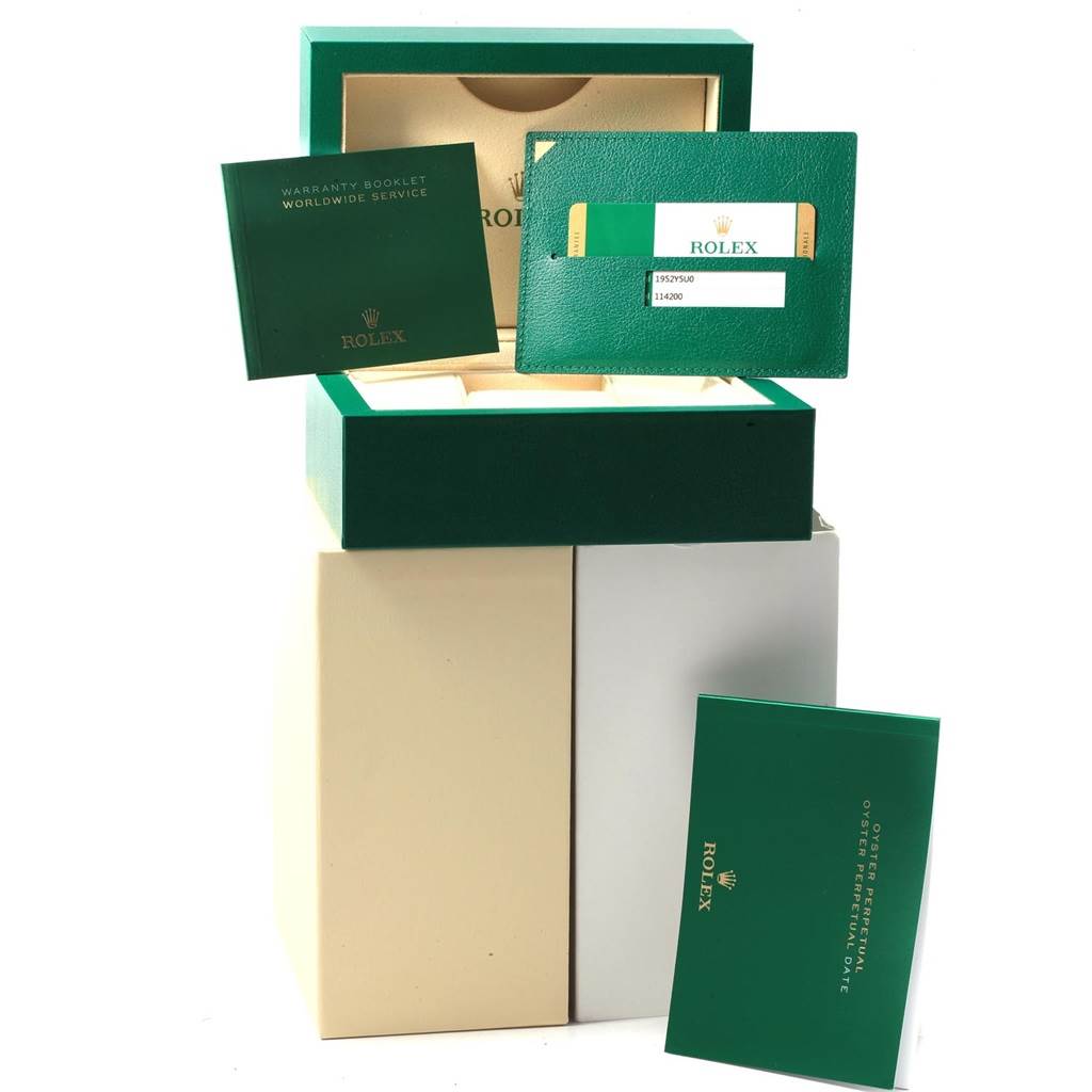 This image shows a Rolex Oysterquartz 114200 Men
s Stainless Steel Burgundy Dial 114200 Men
s Stainless Steel Burgundy Dial packaging with warranty booklets and a green Rolex card from a frontal angle.