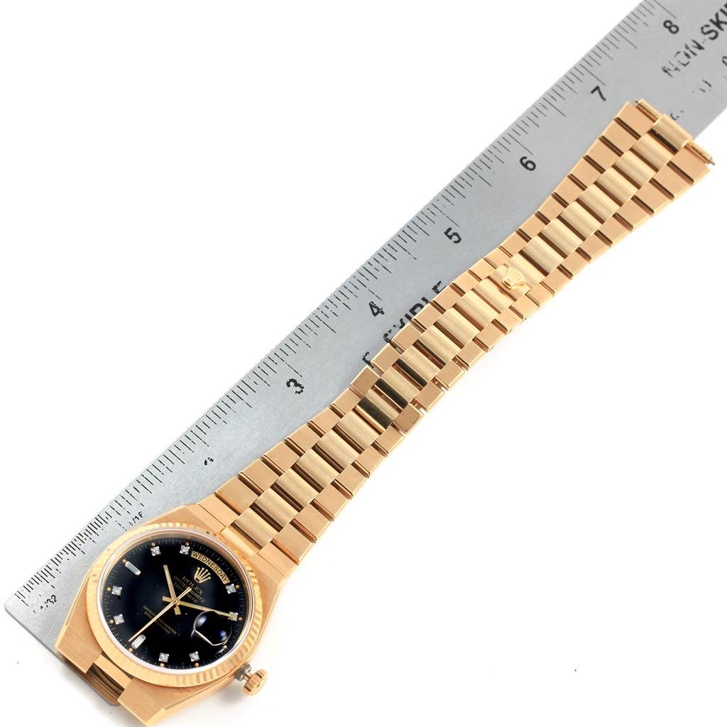 The Rolex Oysterquartz 19018 Men's Yellow Gold Black Dial 19018 Men's Yellow Gold Black Dial watch is displayed at an angle, showing the full bracelet and dial alongside a ruler for scale.