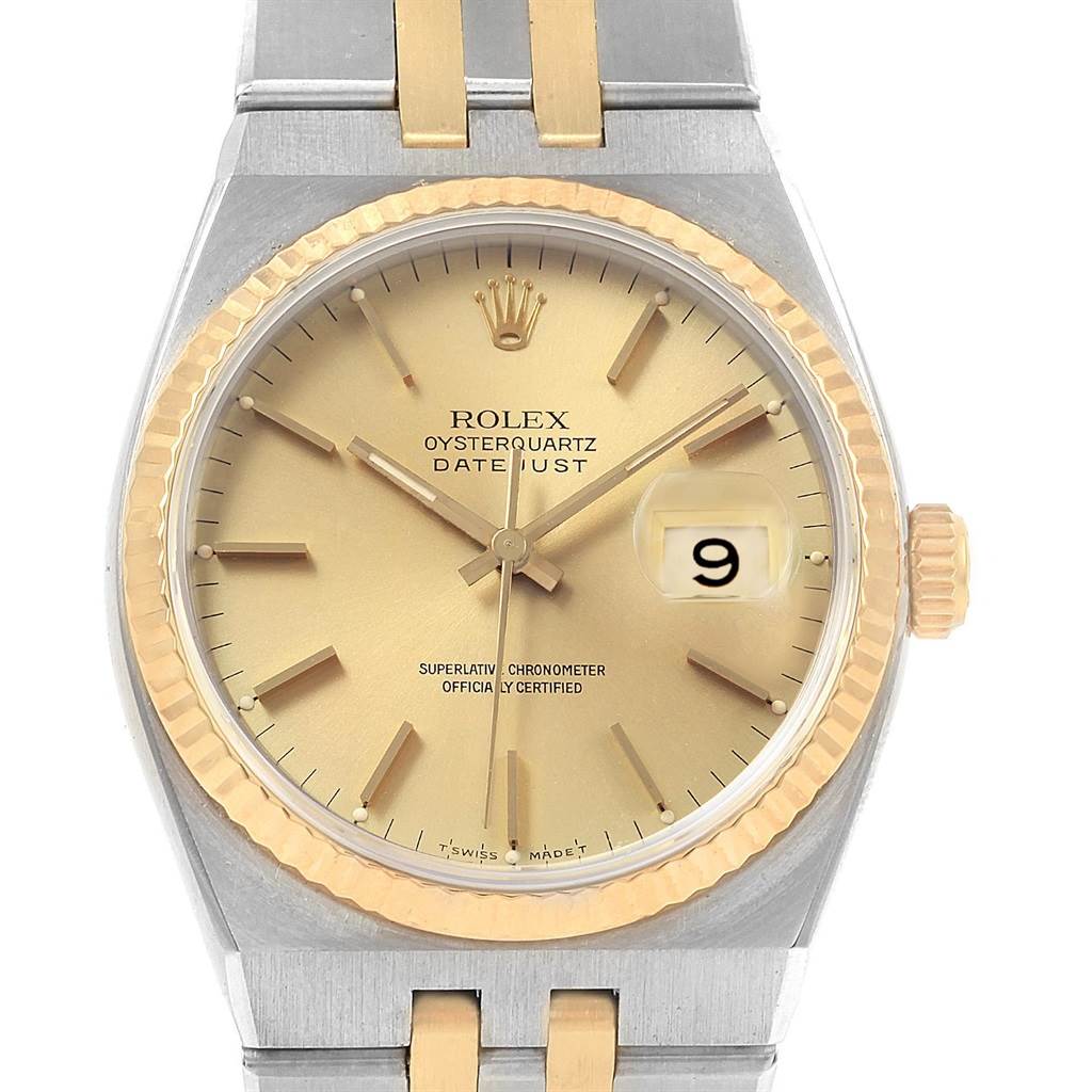 The Rolex Oysterquartz 17013 Men
s Stainless Steel Champagne Dial 17013 Men
s Stainless Steel Champagne Dial watch is shown from a front angle, displaying its gold face, date window, and part of the two-tone metal bracelet.