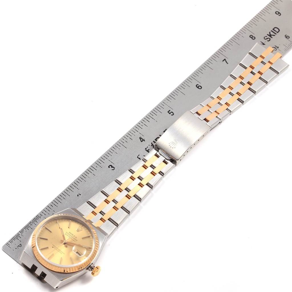 The image shows a Rolex Oysterquartz 17013 Men
s Stainless Steel Champagne Dial 17013 Men
s Stainless Steel Champagne Dial watch laid flat with its strap and dial visible, next to a ruler for size reference.
