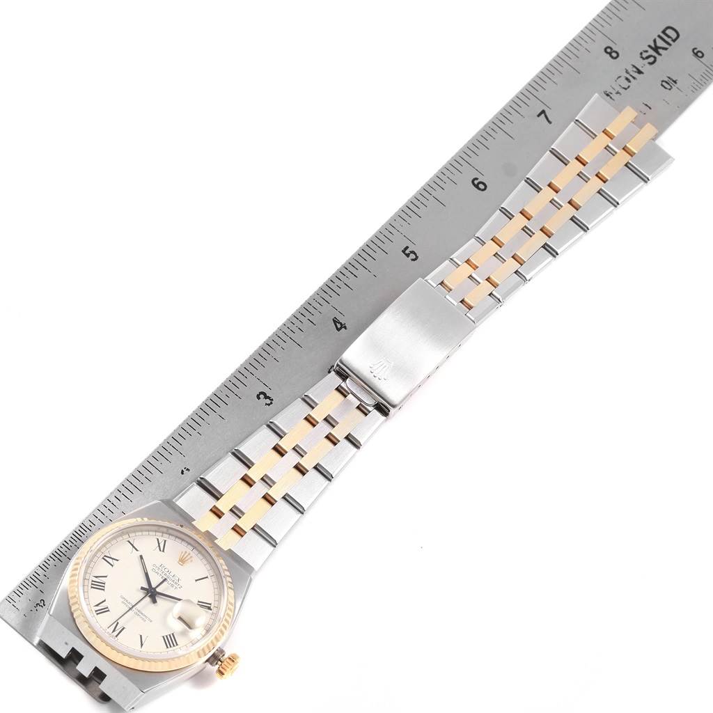 The image shows a Rolex Oysterquartz 17013 Men's Steel and Gold (two tone) White Dial 17013 Men's Steel and Gold (two tone) White Dial watch laid flat alongside a ruler, displaying the watch face and the metal bracelet.