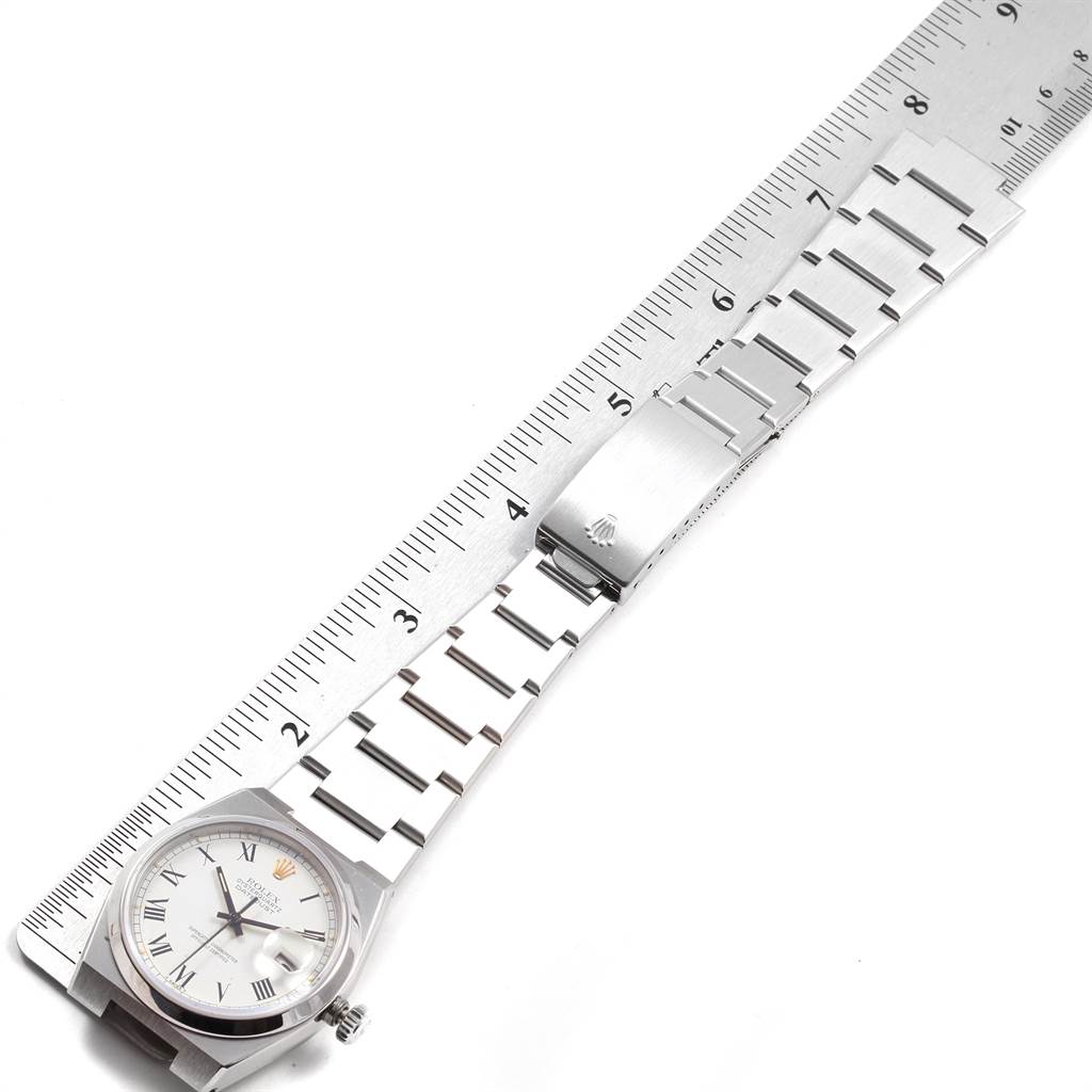 The image displays the Rolex Oysterquartz 17000 Men
s Stainless Steel White Dial 17000 Men
s Stainless Steel White Dial watch laid alongside a ruler, showing the watch face, bracelet, and clasp from a top-down angle.