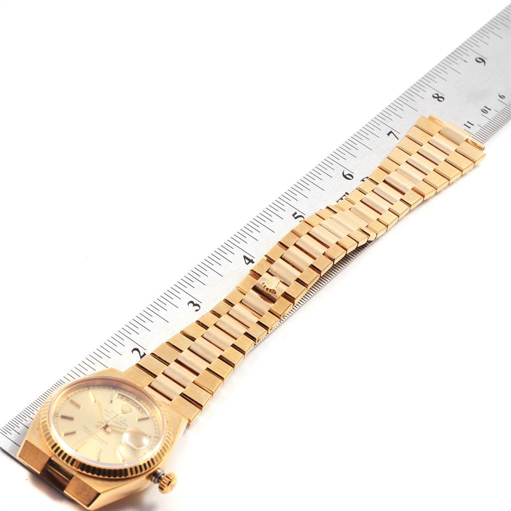 The image shows a Rolex Oysterquartz 19018 Men
s Yellow Gold Champagne Dial 19018 Men
s Yellow Gold Champagne Dial watch laid flat, displaying the watch face, bracelet, and clasp alongside a ruler for scale.