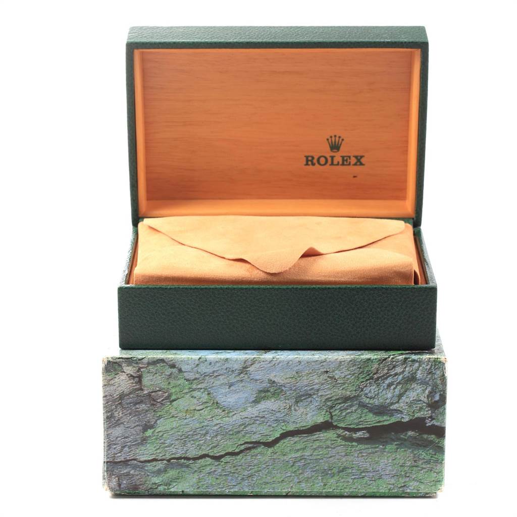 The image shows an open green Rolex watch box containing a wrapped Oysterquartz model.