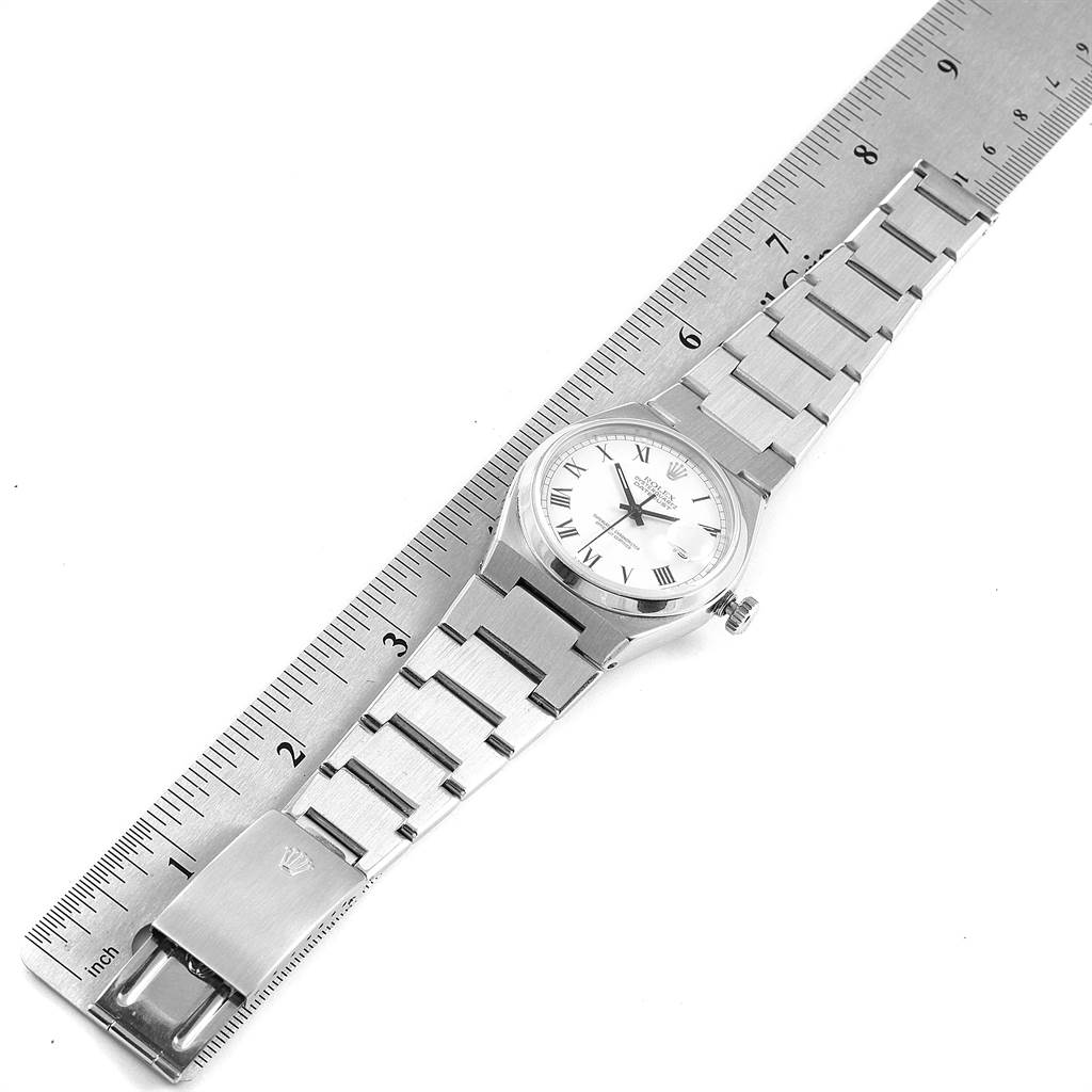 The image shows a top-down view of a Rolex Oysterquartz 17000 Men's Stainless Steel White Dial 17000 Men's Stainless Steel White Dial watch next to a ruler, displaying its bracelet, clasp, and dial.