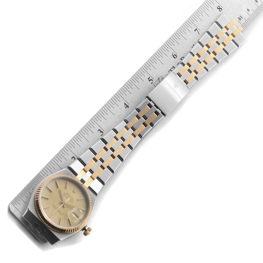 The image shows a Rolex Oysterquartz 17013 Men
s Stainless Steel Champagne Dial 17013 Men
s Stainless Steel Champagne Dial watch from an overhead view, displaying the dial, bezel, crown, and bracelet against a ruler.