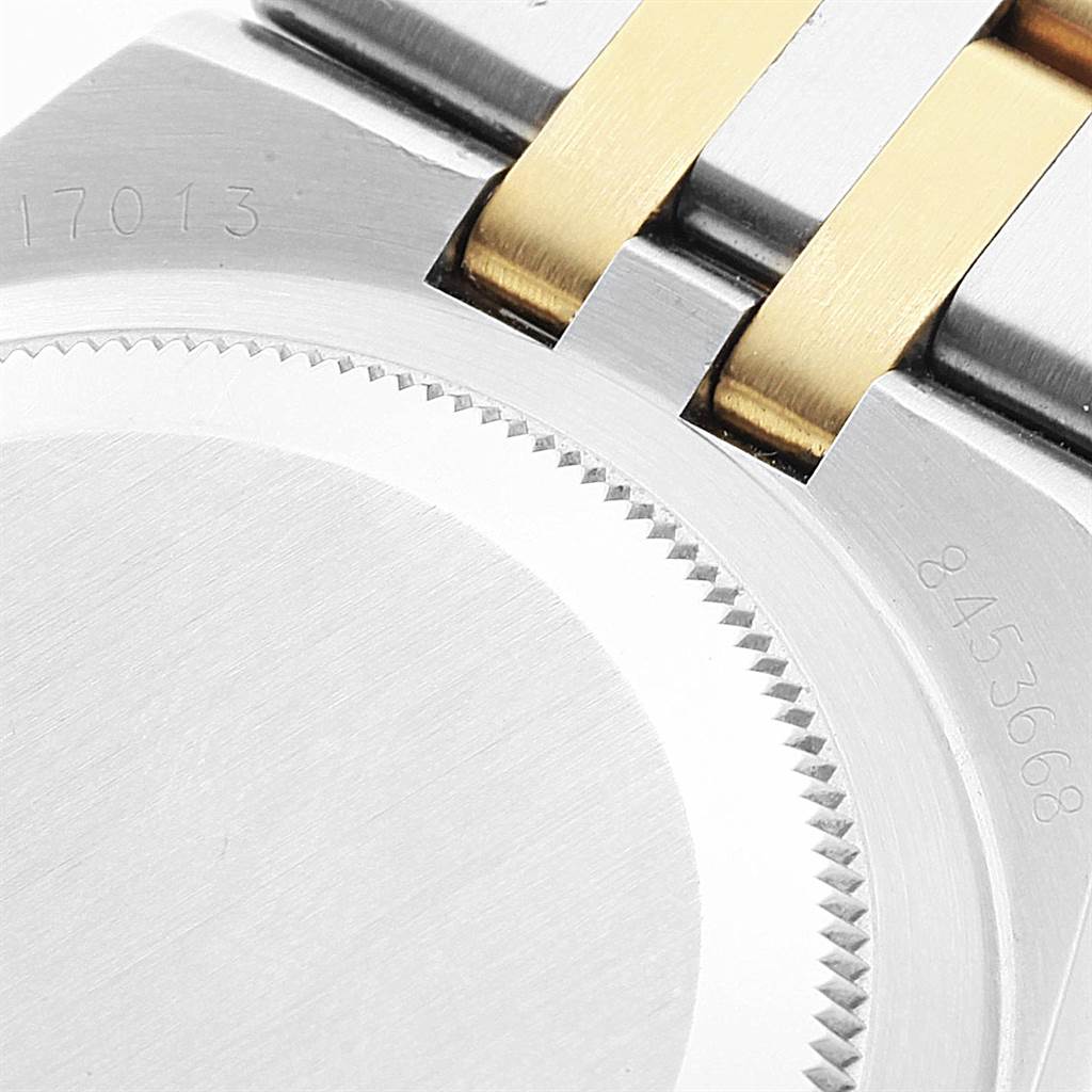 The image shows the case back and part of the bracelet of a Rolex Oysterquartz 17013 Men
s Stainless Steel Champagne Dial 17013 Men
s Stainless Steel Champagne Dial watch, highlighting stainless steel and gold elements.