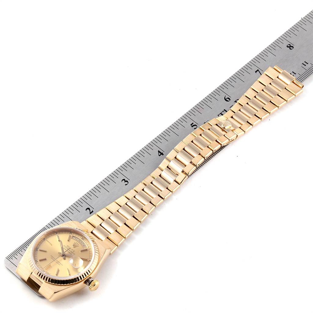 The Rolex Oysterquartz 19018 Men's Yellow Gold Champagne Dial 19018 Men's Yellow Gold Champagne Dial model watch is shown flat with its golden bracelet next to a ruler for scale.