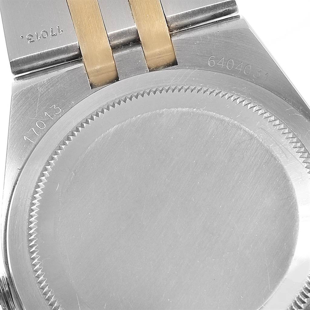 The image shows the case back of a Rolex Oysterquartz 17013 Men
s Stainless Steel Champagne Dial 17013 Men
s Stainless Steel Champagne Dial watch, highlighting the serial number and part of the two-tone bracelet.