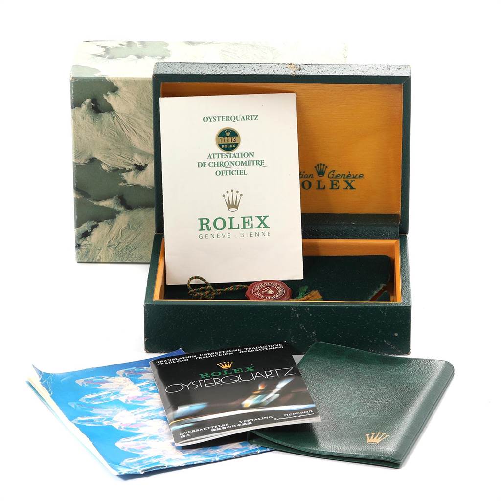 The image shows a Rolex Oysterquartz 17013 Men
s Stainless Steel Champagne Dial 17013 Men
s Stainless Steel Champagne Dial box, papers, and booklets at an angle that displays the open box contents and accompanying documentation.