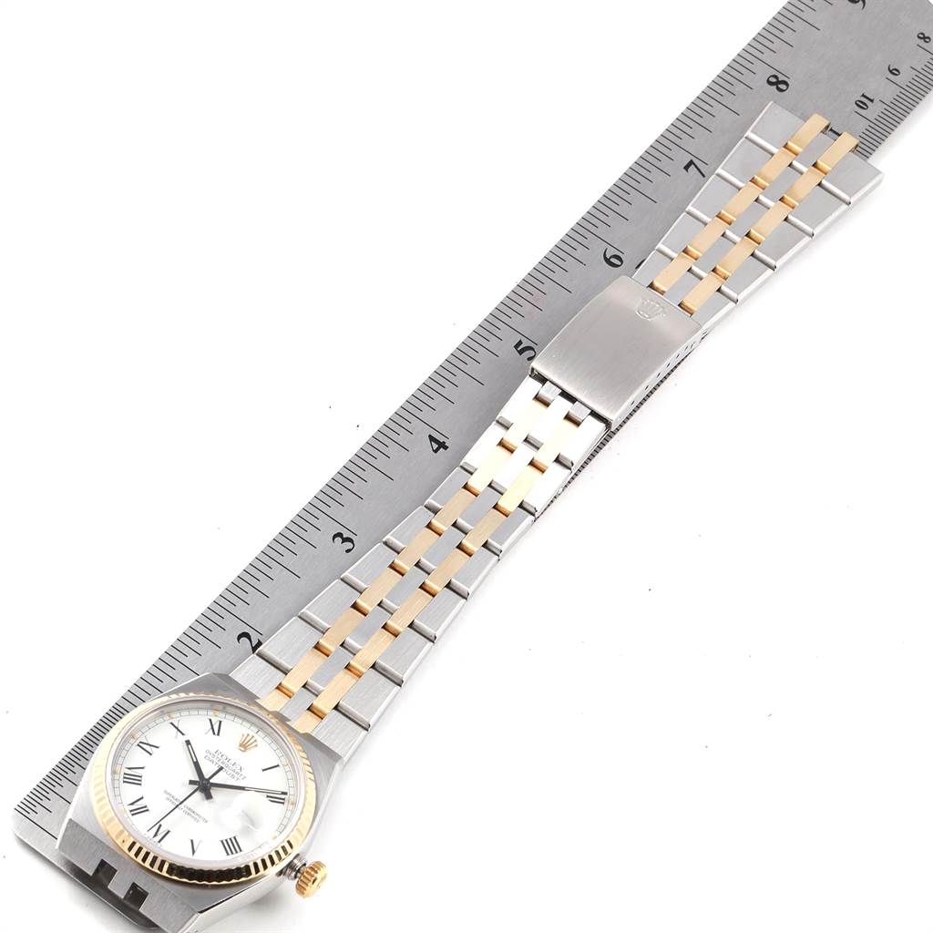 The image shows a Rolex Oysterquartz 19220 Men's Steel and Gold (two tone) White Dial 19220 Men's Steel and Gold (two tone) White Dial watch laid flat alongside a ruler, displaying its face and full bracelet.