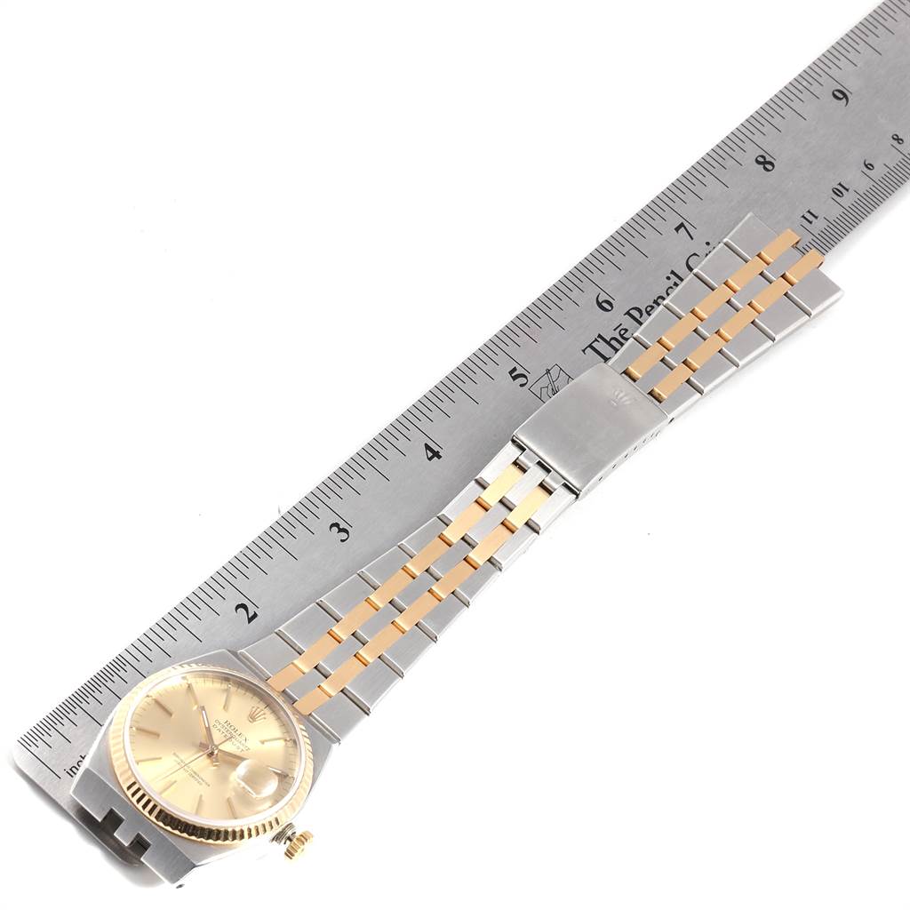 The Rolex Oysterquartz 17013 Men
s Stainless Steel Champagne Dial 17013 Men
s Stainless Steel Champagne Dial watch is shown from an overhead angle, with a ruler measuring its two-tone bracelet.