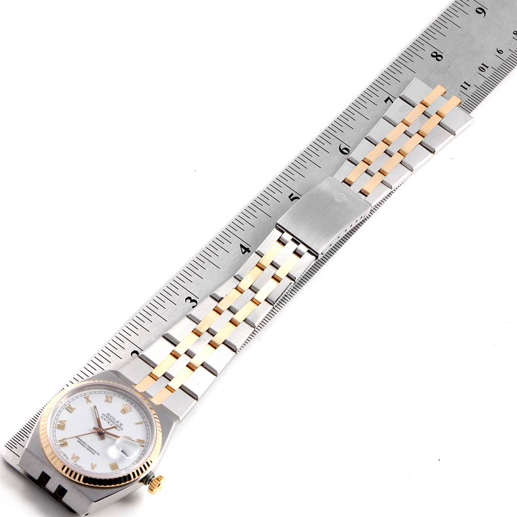 The image shows a Rolex Oysterquartz 16865 Men's Stainless Steel White Dial 16865 Men's Stainless Steel White Dial watch laid flat next to a measuring ruler, highlighting its face, bezel, and metal bracelet.