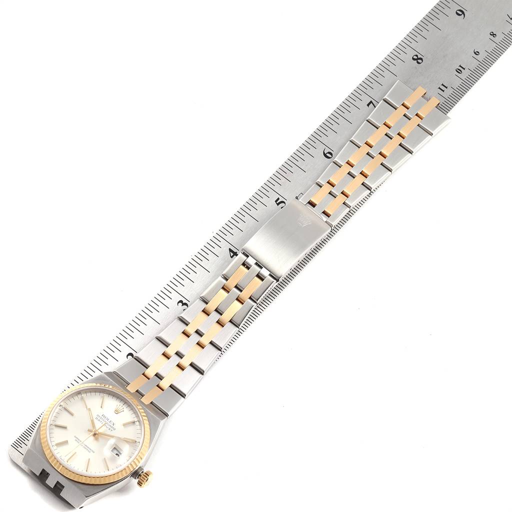 The image shows a Rolex Oysterquartz 17013 Men
s Stainless Steel Silver Dial 17013 Men
s Stainless Steel Silver Dial watch laid flat next to a ruler, displaying the dial, bezel, bracelet, and clasp.