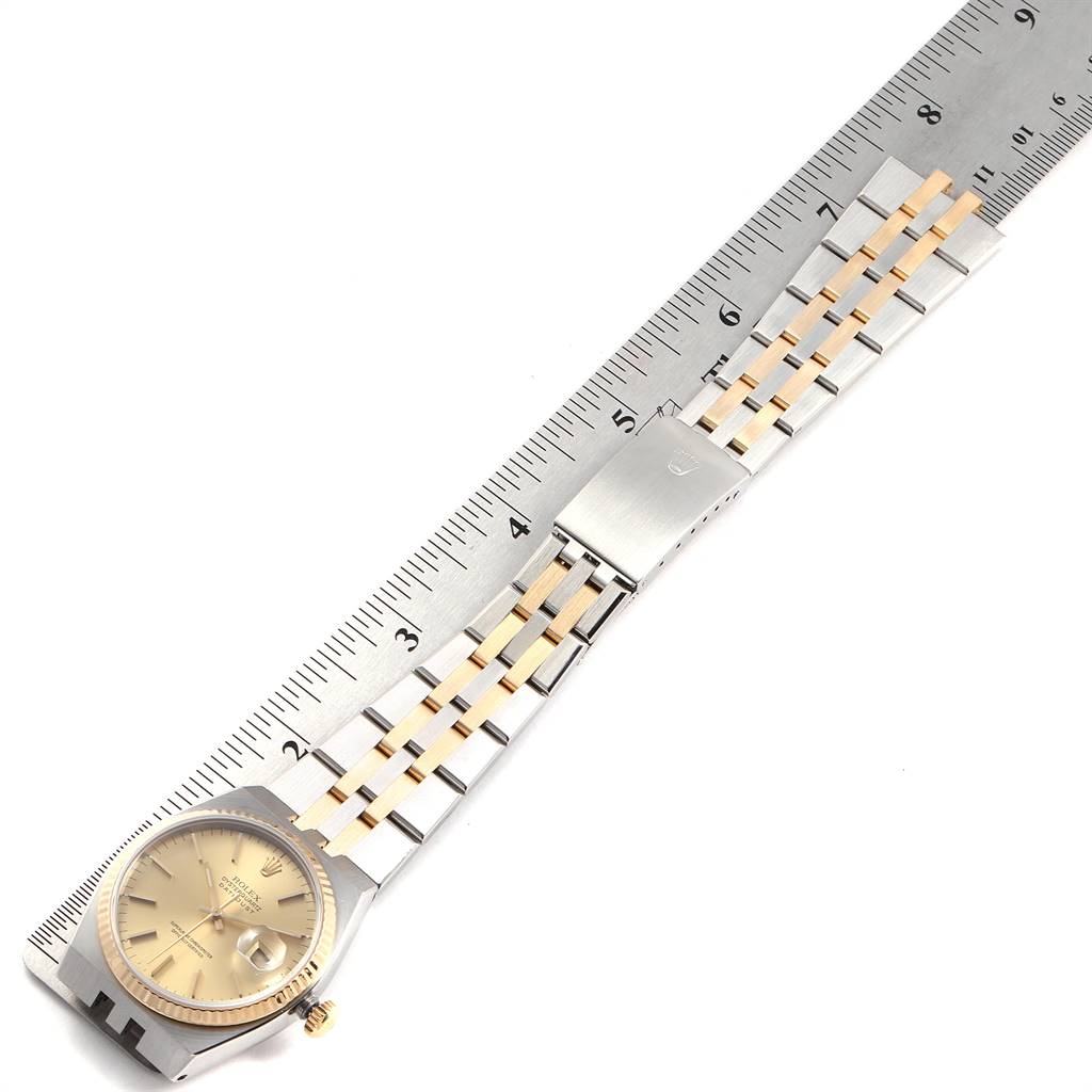 The image shows a Rolex Oysterquartz 17013 Men's Stainless Steel Champagne Dial 17013 Men's Stainless Steel Champagne Dial watch lying flat next to a ruler, displaying its face, band, and clasp.