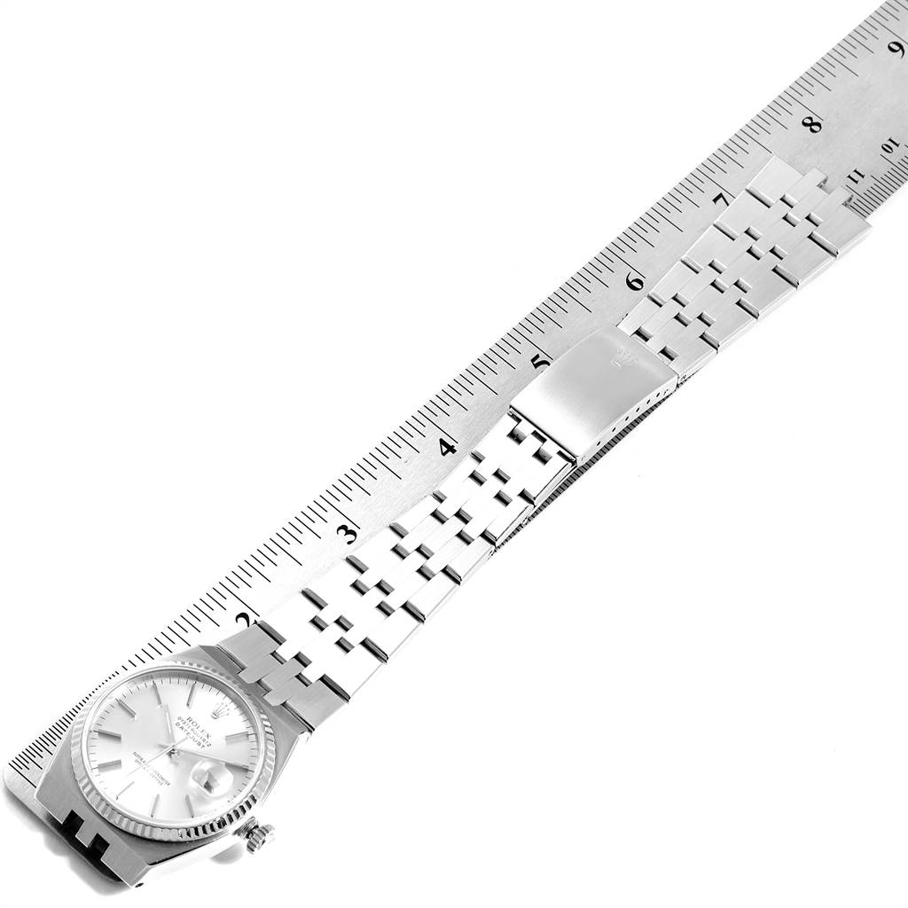 The image shows the Rolex Oysterquartz 17014 Men
s Stainless Steel Silver Dial 17014 Men
s Stainless Steel Silver Dial watch laid flat beside a ruler, displaying the face, bracelet, and clasp.