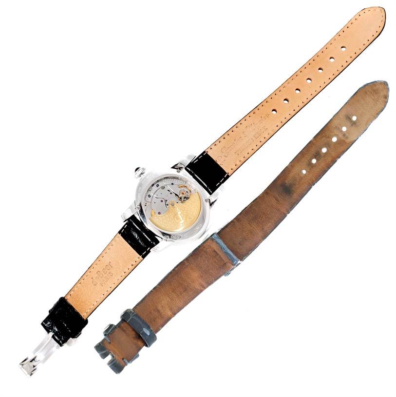 The image shows the backside of the Girard Perregaux Cat's Eye 18K White Gold Diamond Watch 80481 by Girard-Perregaux 80481 Women's White Gold Mother of Pearl Dial 80481 Women's White Gold Mother of Pearl Dial and a separate leather strap.