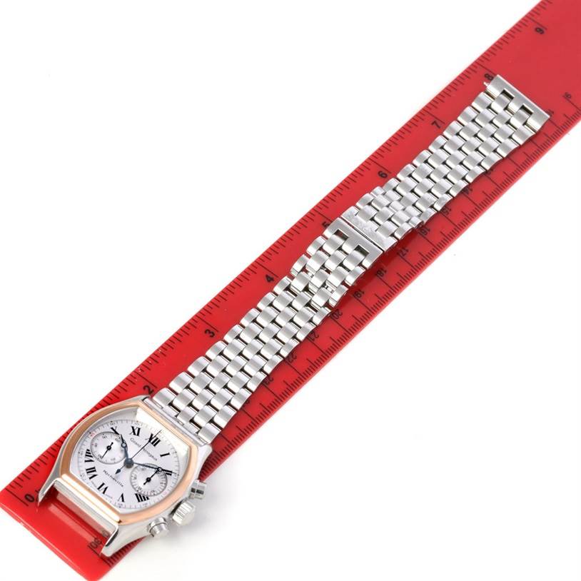 The Girard-Perregaux 2710 Men's Stainless Steel Silver Dial 2710 Men's Stainless Steel Silver Dial Richeville Chronograph Steel and Rose Gold Watch 2710 is shown lying flat on a red ruler with its full strap visible.