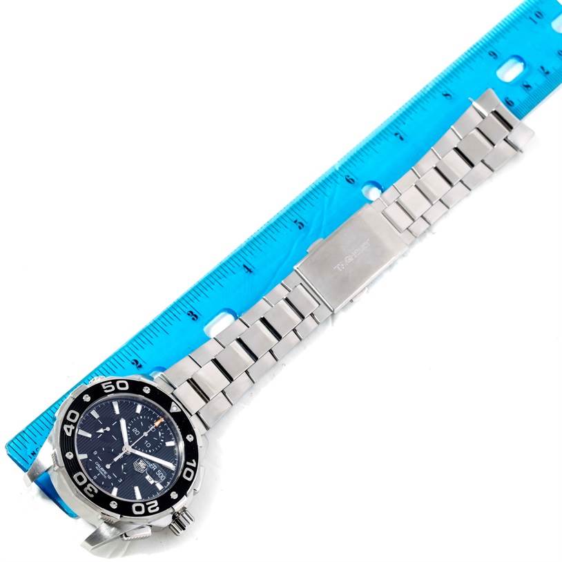 The image shows a Tag Heuer Aquaracer CAJ2110.BA0872 Men's Stainless Steel Black Dial CAJ2110.BA0872 Men's Stainless Steel Black Dial watch laid flat next to a ruler, highlighting its stainless steel bracelet and clasp.