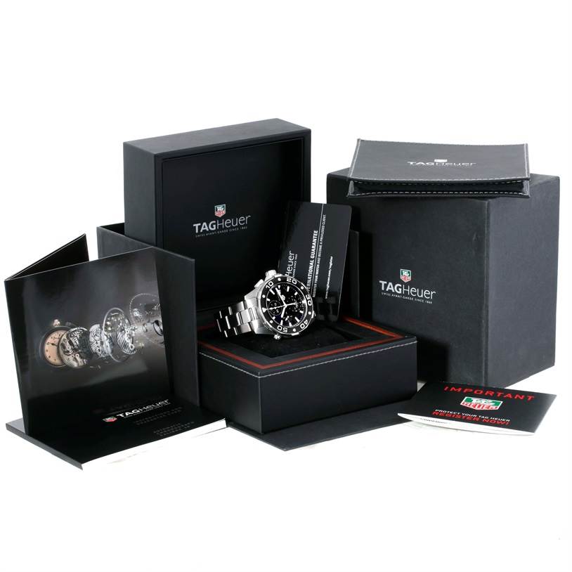 The image shows a Tag Heuer Aquaracer CAJ2110.BA0872 Men's Stainless Steel Black Dial CAJ2110.BA0872 Men's Stainless Steel Black Dial watch at an oblique angle along with its packaging, manuals, and warranty cards.