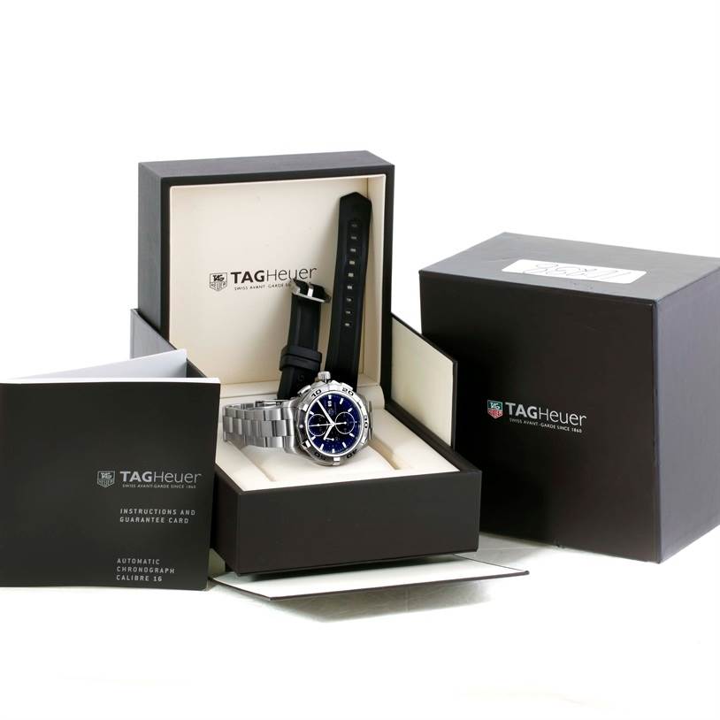 The image shows a Tag Heuer Aquaracer CAP2110.BA0833 Men's Stainless Steel Black Dial CAP2110.BA0833 Men's Stainless Steel Black Dial watch with both a metal and rubber strap, displayed in its open box with accompanying documentation.