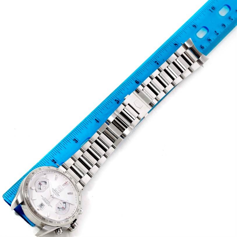 The image shows a Tag Heuer Carrera CAV511B Men's Stainless Steel Silver Dial CAV511B Men's Stainless Steel Silver Dial watch from a top-down angle alongside a blue ruler, highlighting its metal bracelet and clasp.