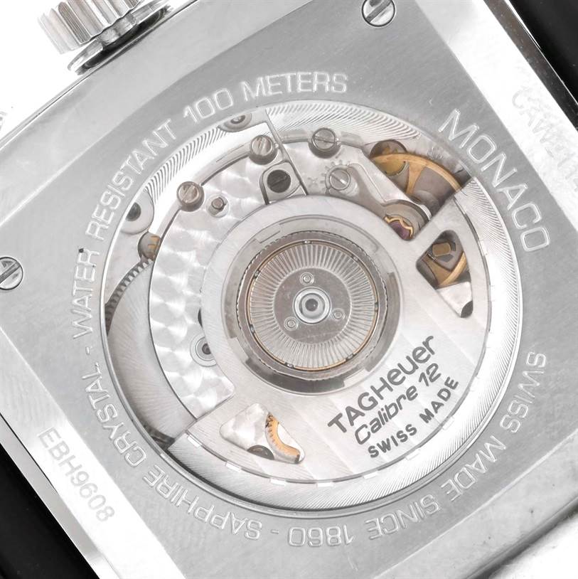 The image shows the back of a Tag Heuer Monaco CAW2114 Men's Stainless Steel Black Dial CAW2114 Men's Stainless Steel Black Dial watch, highlighting its internal Calibre 12 mechanism.