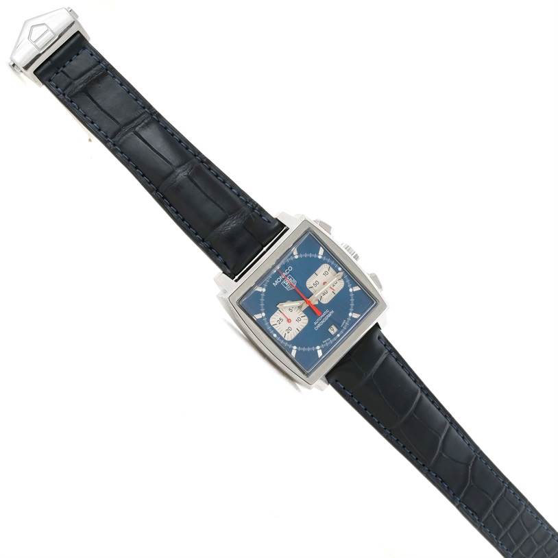 The image shows an overhead view of the Tag Heuer Monaco CW2113 Men's Stainless Steel Blue Dial CW2113 Men's Stainless Steel Blue Dial watch, highlighting its blue dial, square case, and black leather strap.