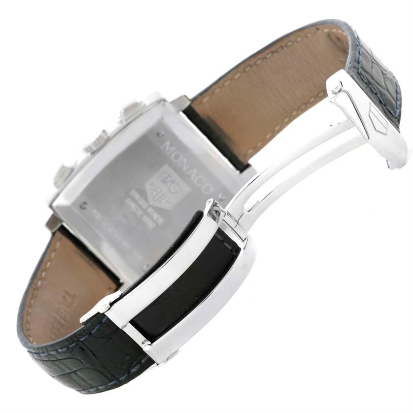 The image shows the back of a Tag Heuer Monaco CW2113 Men
s Stainless Steel Blue Dial CW2113 Men
s Stainless Steel Blue Dial watch and its partially opened leather strap with a deployment clasp.