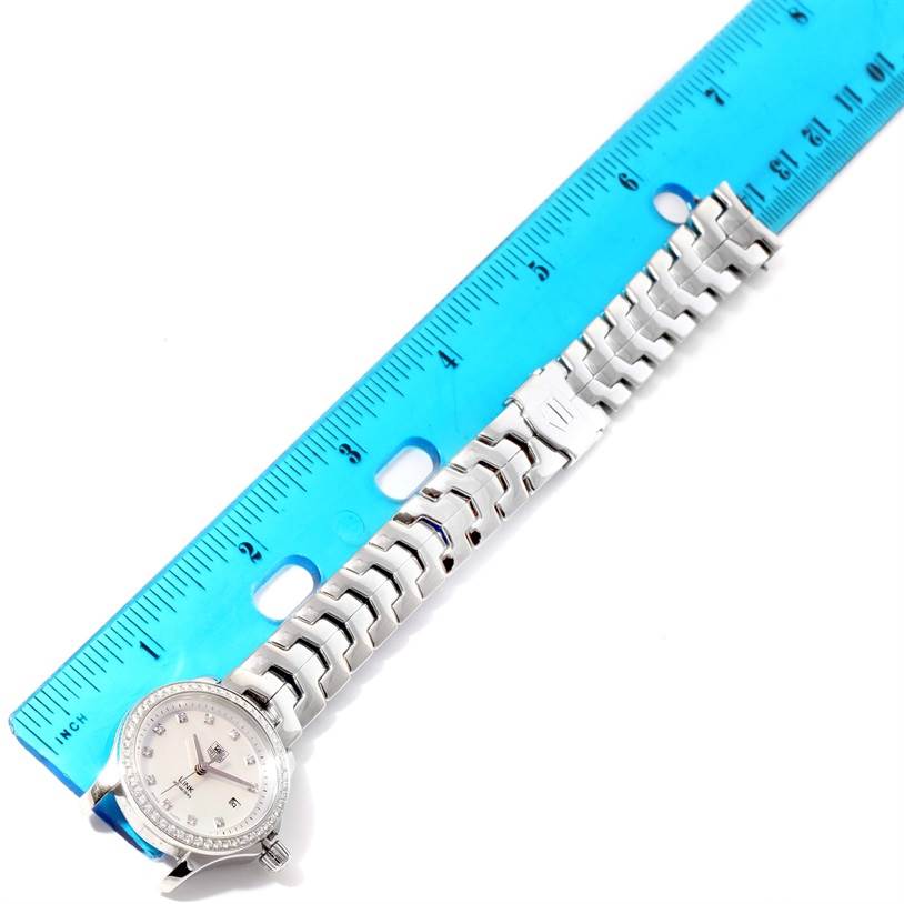 The Tag Heuer Link WJF1319.BA0572 Women's Stainless Steel Mother of Pearl Dial WJF1319.BA0572 Women's Stainless Steel Mother of Pearl Dial watch is shown with its bracelet fully extended next to a blue ruler.