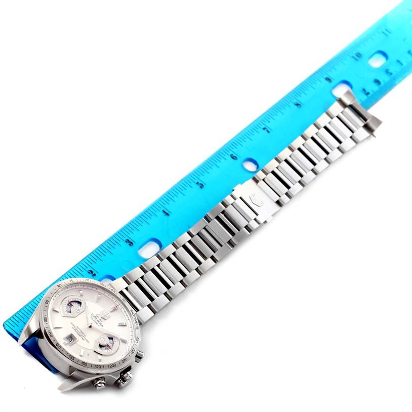 The Tag Heuer Carrera CAV511B Men's Stainless Steel Silver Dial CAV511B Men's Stainless Steel Silver Dial watch is shown on a flat surface with a stainless steel bracelet and a blue ruler beside it for scale.