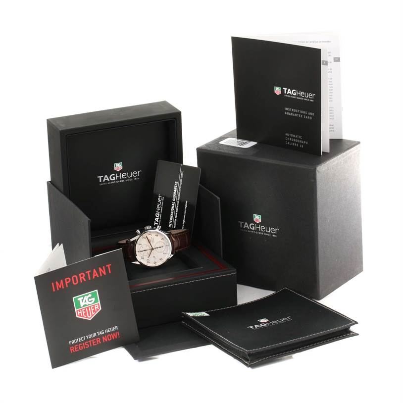 The image shows a Tag Heuer Carrera CAR221A.FC6353 Men
s Stainless Steel Silver Dial CAR221A.FC6353 Men
s Stainless Steel Silver Dial watch at an angle, including its box, manual, guarantee card, and registration card.