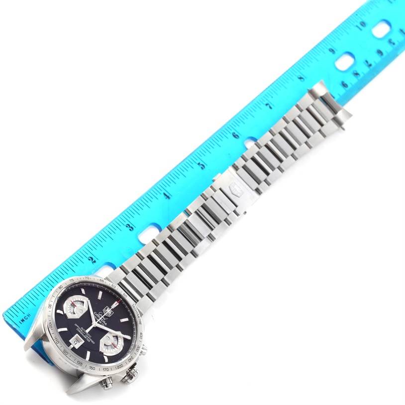 The image shows a Tag Heuer Carrera CAV511A Men
s Stainless Steel Black Dial CAV511A Men
s Stainless Steel Black Dial watch with a metal bracelet aligned next to a blue ruler for scale.