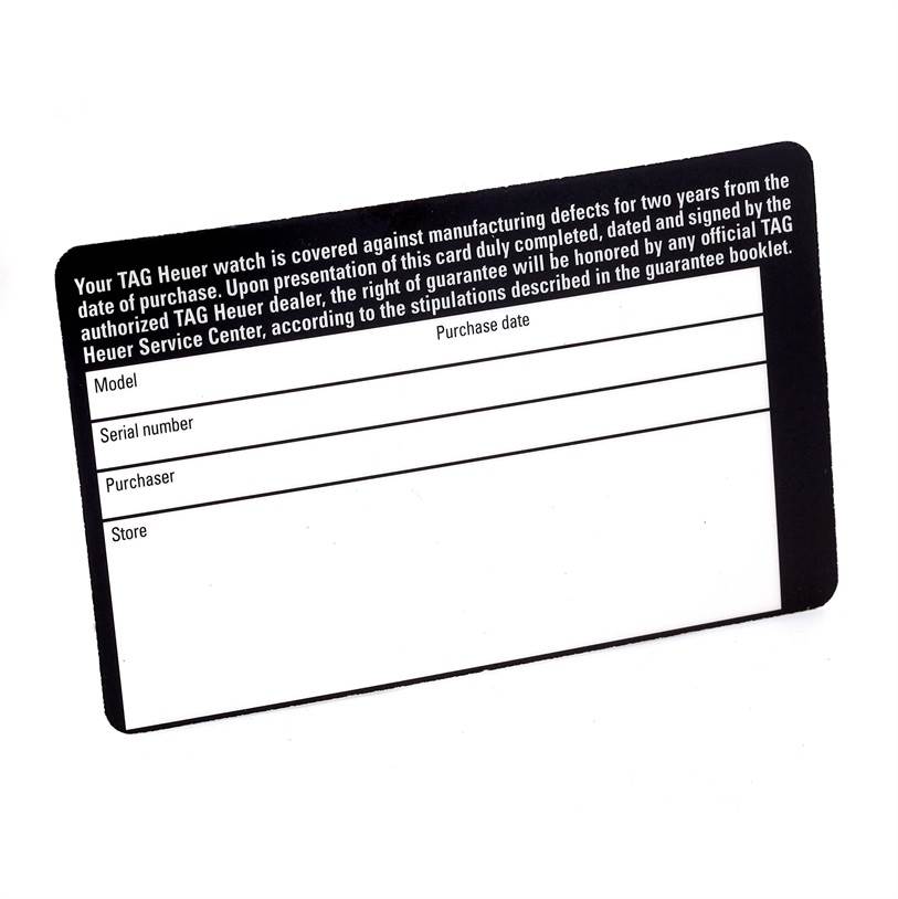 The image shows a warranty card for a Classic model watch by TAG Heuer, photographed from a top-view angle.