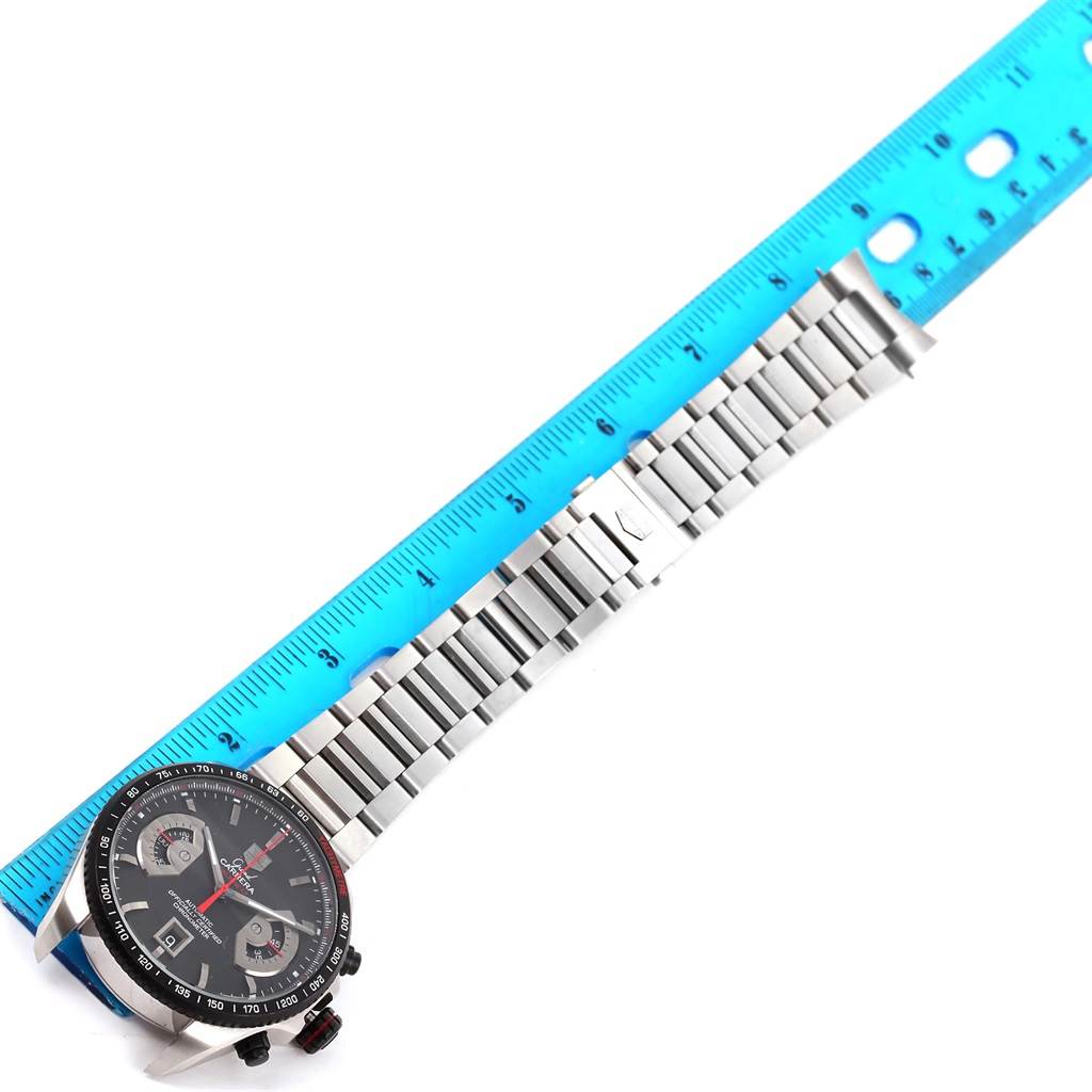 This image shows a Tag Heuer Carrera CAV511C Men's Titanium Black Dial CAV511C Men's Titanium Black Dial watch and its stainless steel bracelet laid next to a blue ruler for measurement.