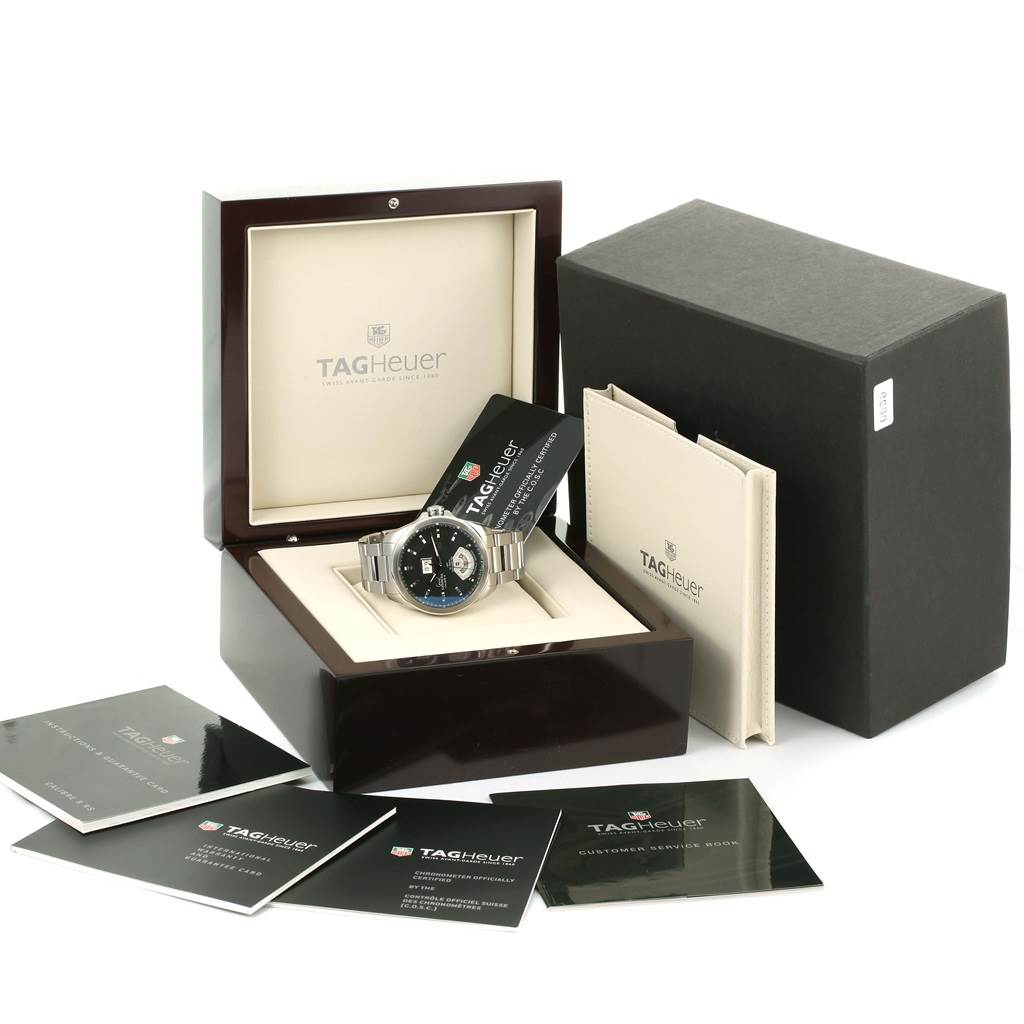 The image shows a Tag Heuer Carrera WAV5111 Men's Stainless Steel Black Dial WAV5111 Men's Stainless Steel Black Dial watch inside its open box, accompanied by various manuals and booklets.