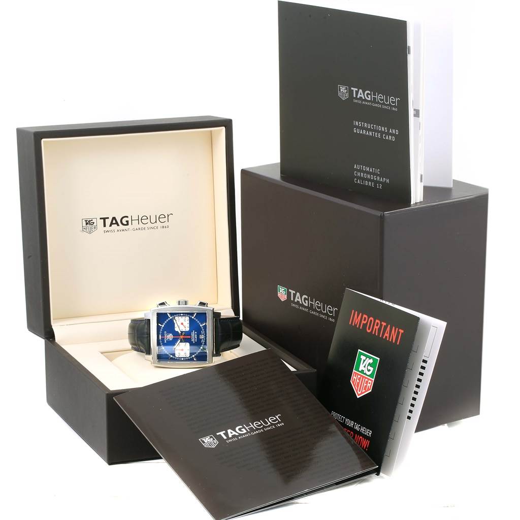 This image shows the Tag Heuer Monaco CAW2111 Men
s Stainless Steel Blue Dial CAW2111 Men
s Stainless Steel Blue Dial watch at an angle in its open box, accompanied by its warranty, instructions, and other booklets.