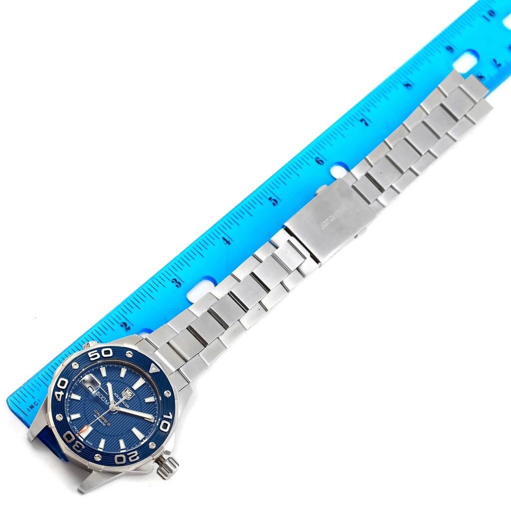 The image shows a Tag Heuer Aquaracer RWC2411 Men's Stainless Steel Blue Dial RWC2411 Men's Stainless Steel Blue Dial watch placed next to a ruler, highlighting the face and stainless steel band.