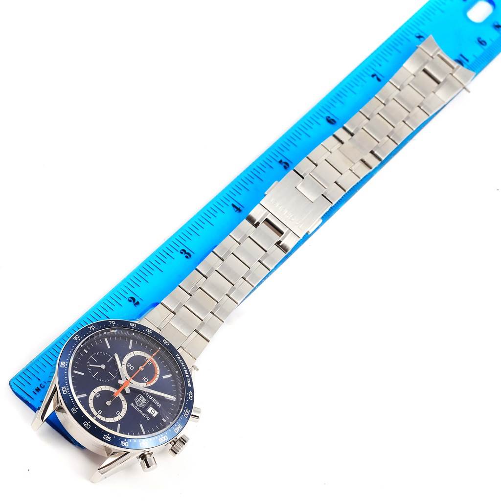 The Tag Heuer Carrera CV2015 Men
s Stainless Steel Blue Dial CV2015 Men
s Stainless Steel Blue Dial watch is shown from a top-down angle with part of the metal bracelet aligned with a blue ruler.