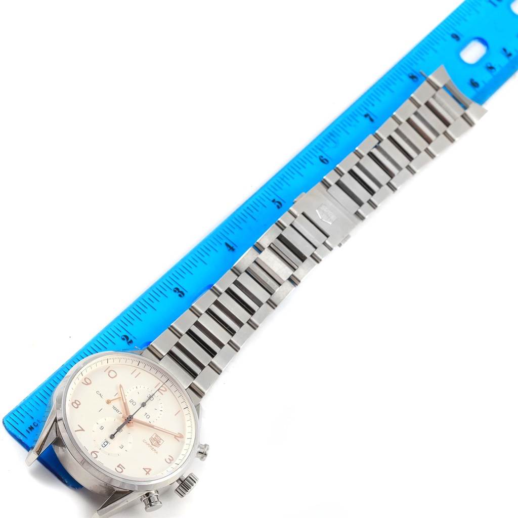 The image shows a Tag Heuer Carrera CAR2012.BA0796 Men's Stainless Steel Silver Dial CAR2012.BA0796 Men's Stainless Steel Silver Dial watch with a stainless steel bracelet laid out next to a blue ruler for measurement.