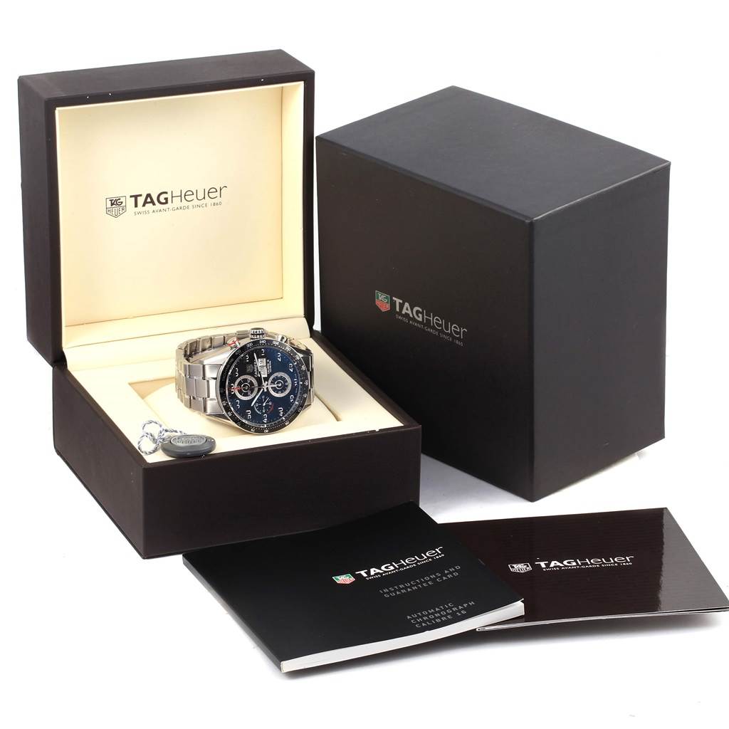 The image shows a Tag Heuer Carrera CV2A10.BA0796 Men's Stainless Steel Black Dial CV2A10.BA0796 Men's Stainless Steel Black Dial watch and its accessories, including its box and manuals, from a slightly elevated front angle.