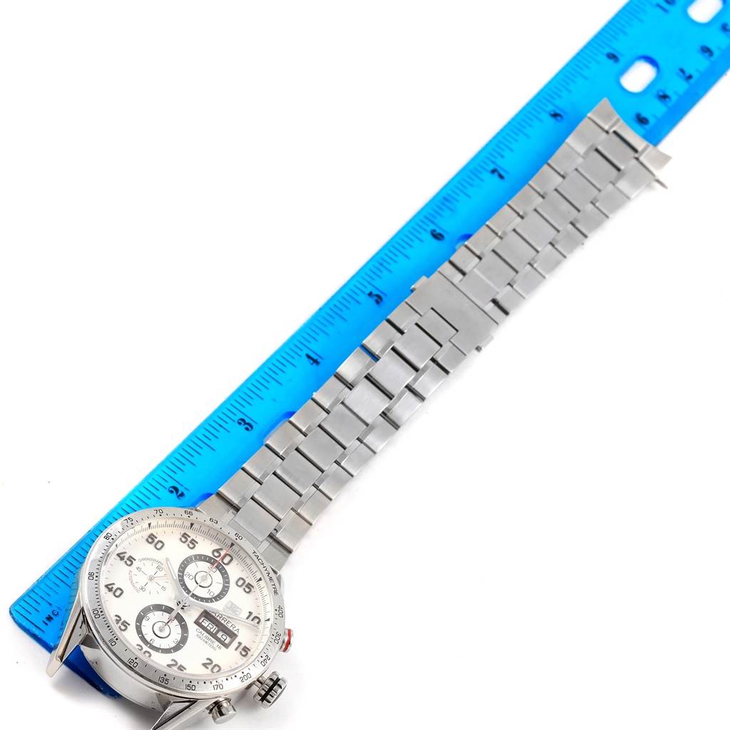 The Tag Heuer Carrera CV2A11.BA0796 Men's Stainless Steel Silver Dial CV2A11.BA0796 Men's Stainless Steel Silver Dial watch is laid flat, showing the face, bezel, and metal bracelet next to a ruler for scale.