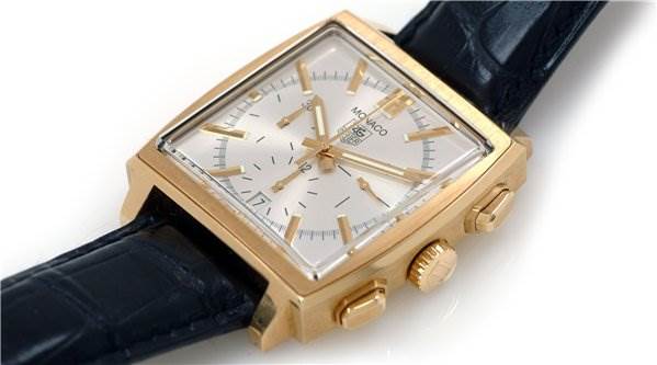 The image shows a side-angle view of a Monaco model watch by Tag Heuer, highlighting the crown, pushers, and leather strap.